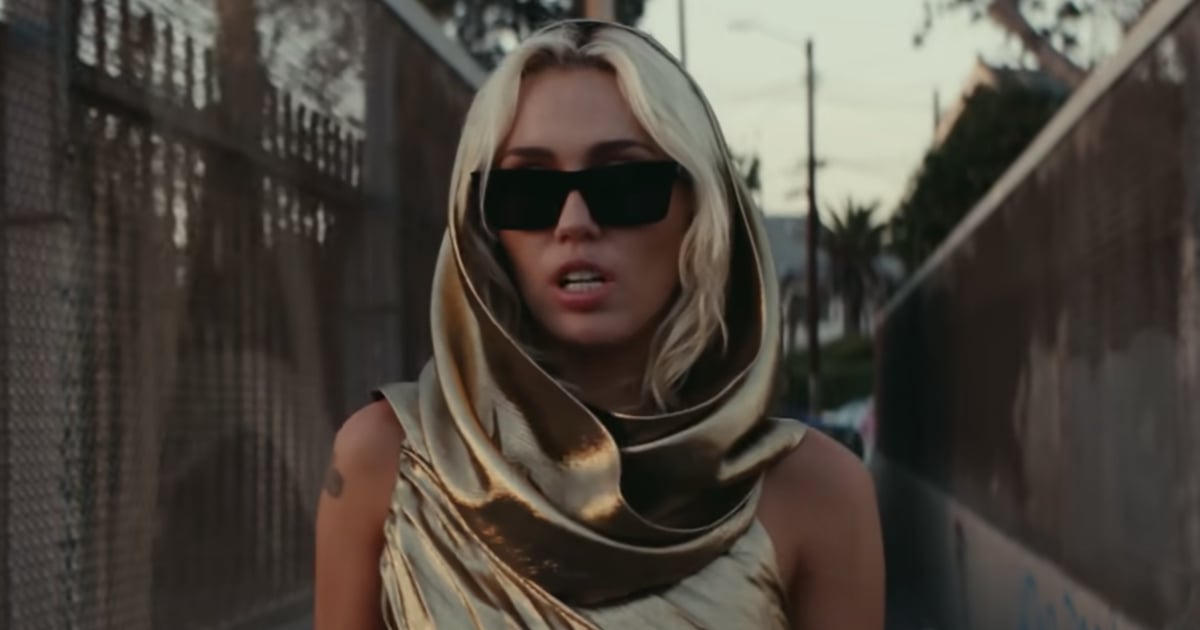 Miley Cyrus poartă o rochie decupată auriu în videoclipul „Flowers”.