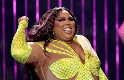 Lizzo poartă un costum de pisică neon cu paiete în timpul unui turneu special