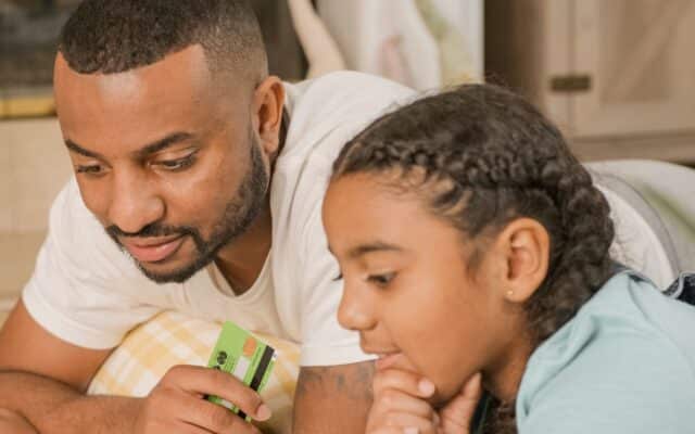 Tata si fiica verifica un card bancar