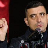 Lider politic la microfon cu pumnul ridicat in