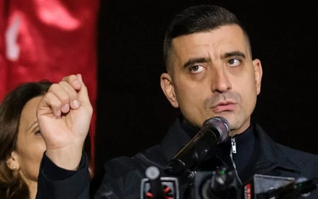 Lider politic la microfon cu pumnul ridicat in