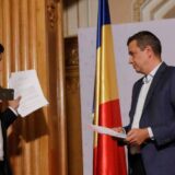 Document fotografiat cu telefonul in fata unui barbat