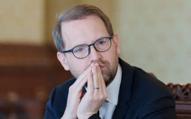 Barbat cu mainile impreunate la fata, ingandurat