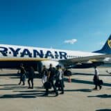 Pasageri lângă avion pentru bilete scumpe