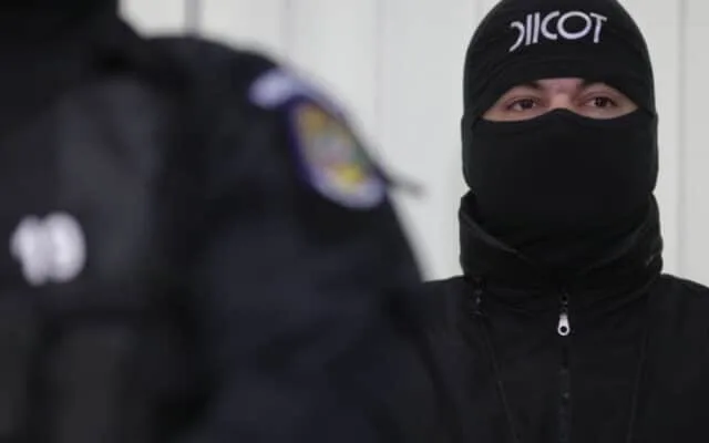 Ofițer DIICOT cu fața acoperită de cagulă