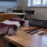 Rechizite școlare și eșarfă în culorile clubului sportiv pe o bancă