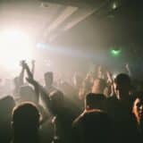 O imagine de atmosferă dintr-un club de noapte aglomerat, cu oameni dansând pe un ring de dans