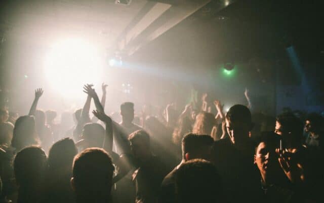 O imagine de atmosferă dintr-un club de noapte aglomerat, cu oameni dansând pe un ring de dans