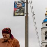 Femeie lângă portretul unui militar Russian