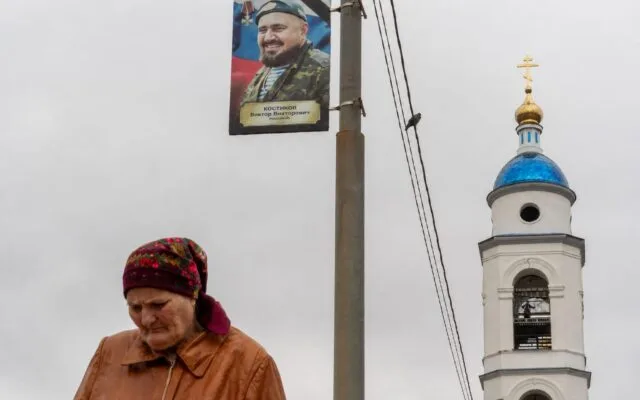 Femeie lângă portretul unui militar Russian