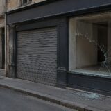 Vitrina spartă a unui magazin închis de pe o stradă urbană
