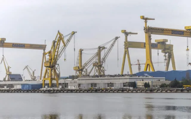 Utilaje și macarale de mari dimensiuni la un șantier naval