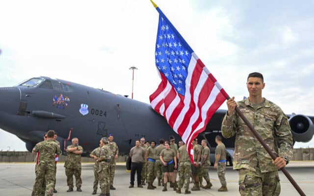 Militari americani cu drapelul SUA, pe o bază aeriană