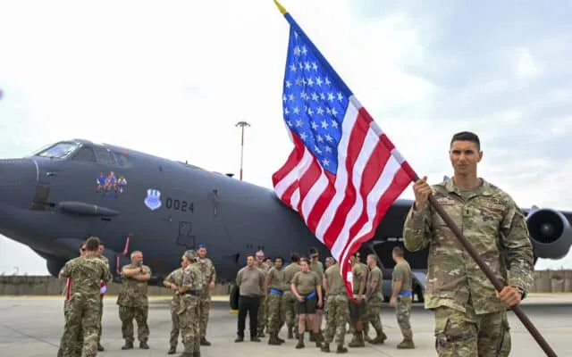 Militari americani cu drapelul SUA, pe o bază aeriană