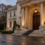 Intrarea principală a unei clădiri istorice cu arhitectură clasică impunătoare