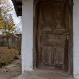 Ușa unei locuințe modeste din mediul rural într-un decor de toamnă